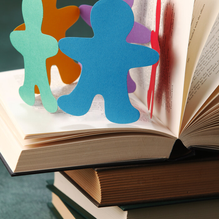 Figure di carta unite sopra un libro aperto